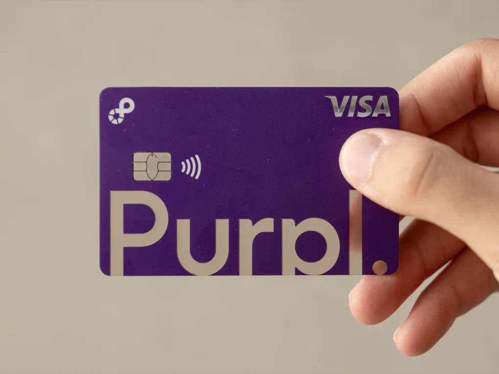 A hand holding the printed Purpl card